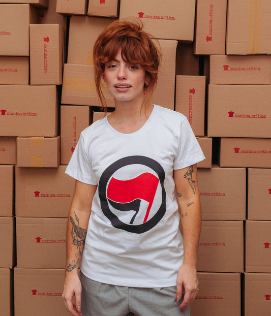 Mulher vestindo camiseta baby look. Símbolo da Ação Antifascista. Uma bandeira menor e outra maior envoltas por um círculo. 