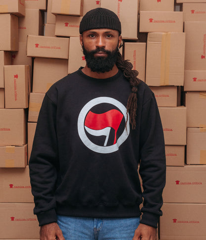 Homem vestindo Moletom Estampa: Símbolo da Ação Antifascista. Uma bandeira menor e outra maior envoltas por um círculo. 