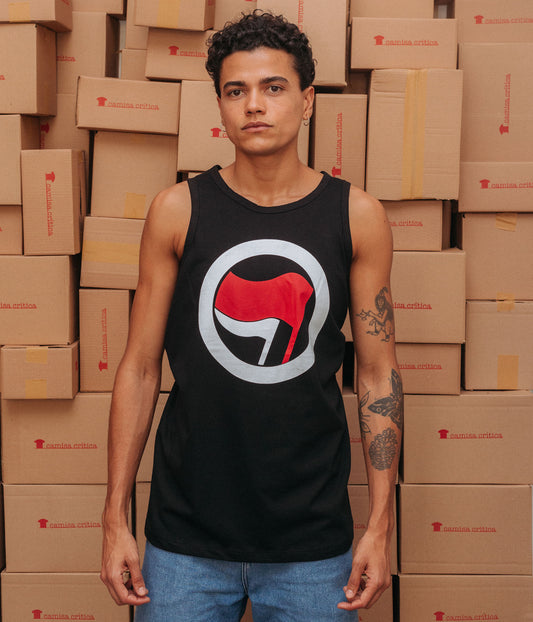 Homem vestindo Camiseta Regata. Estampa: Símbolo pequeno na altura do peito à direita da Ação Antifascista. Uma bandeira menor e outra maior envoltas por um círculo. 