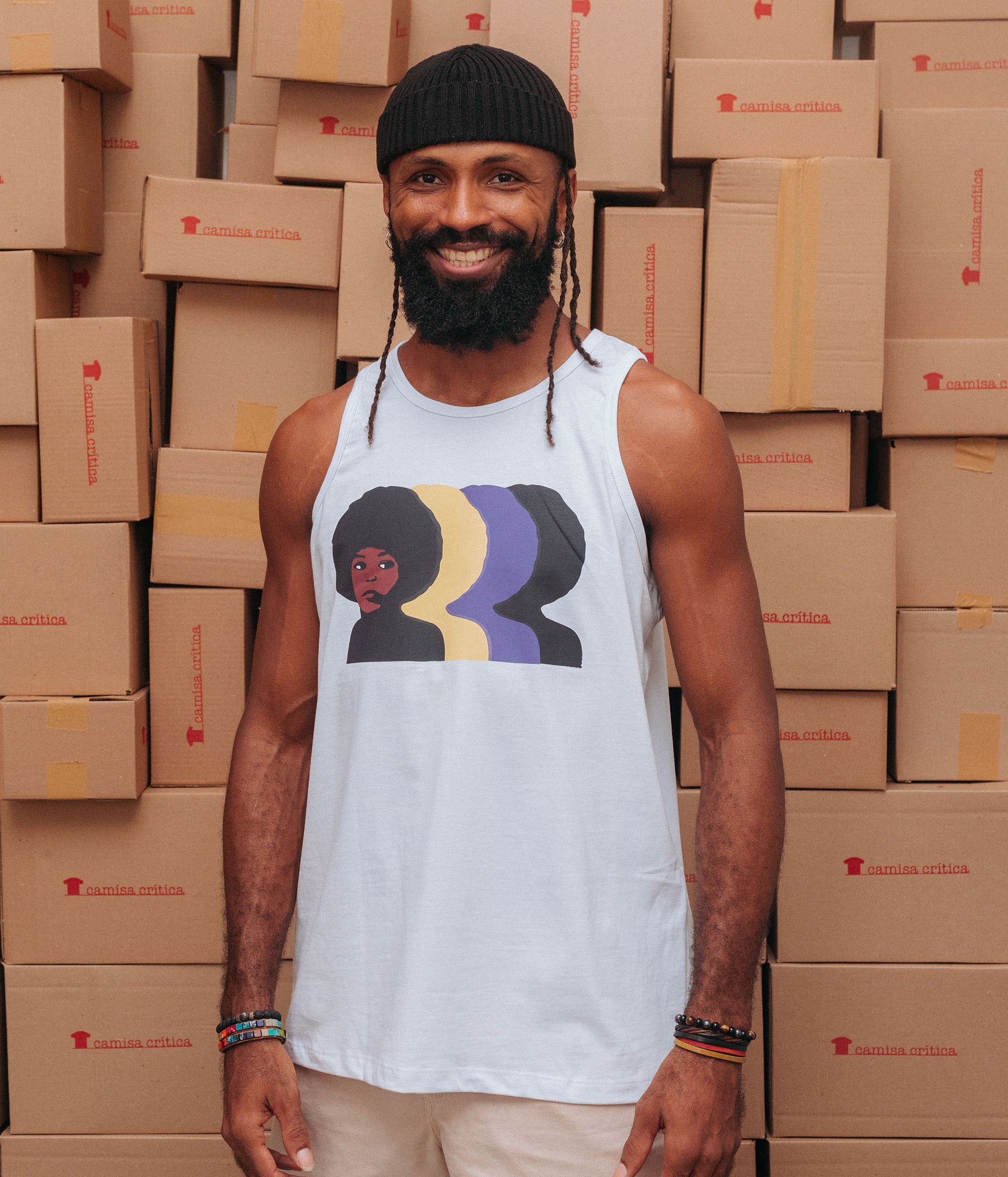 Homem vestindo Camiseta Regata. Estampa: Angela davis de perfil com três cópias coloridas do seu perfil por trás 1a direita.