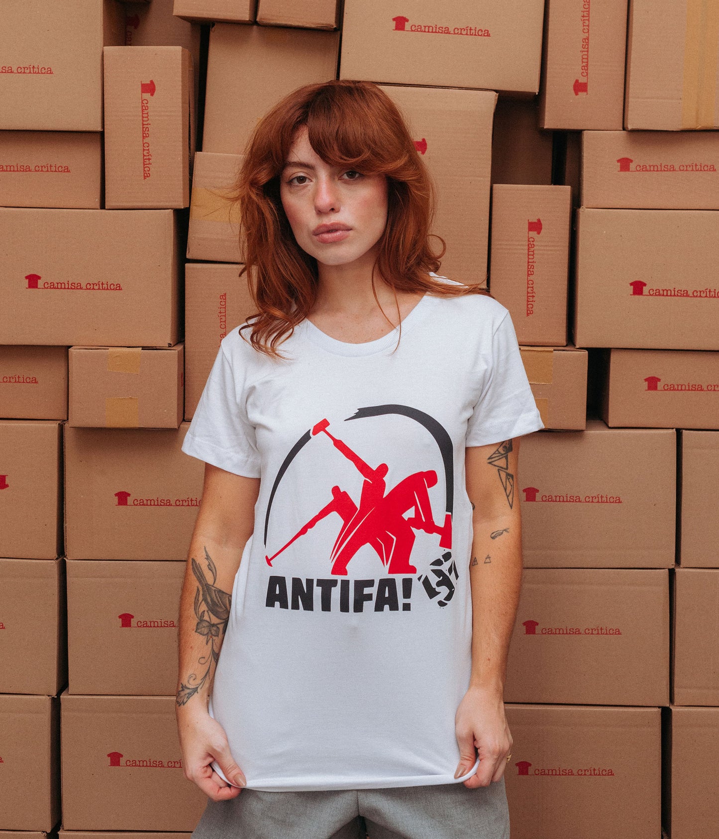 Mulher vestindo Camiseta Baby Look Estampa:  Imagem sequência de uma marretada num suástica com o texto ANTIFA! abaixo