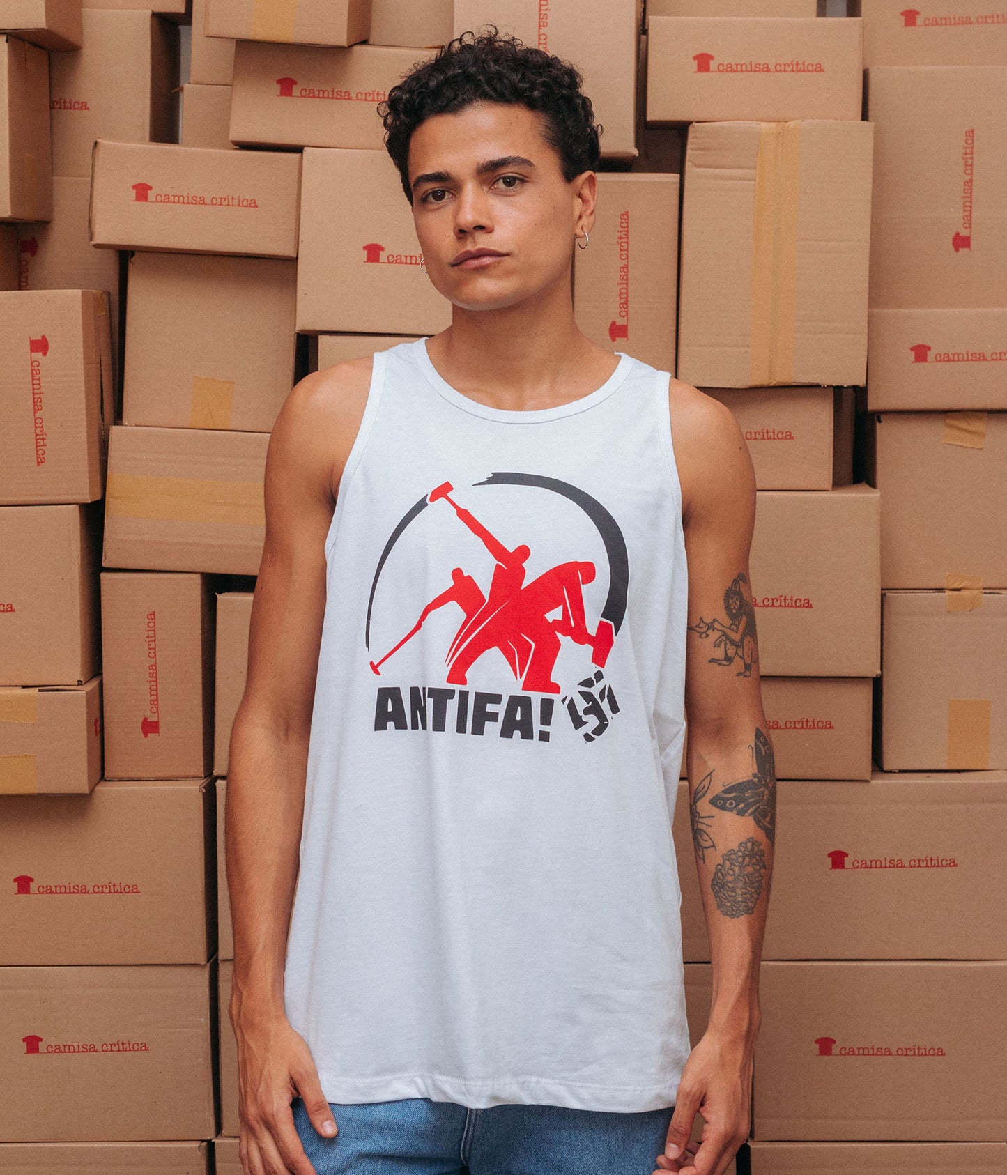 Homem vestindo Camiseta Regata. Estampa: Imagem sequência de uma marretada num suástica com o texto ANTIFA! abaixo