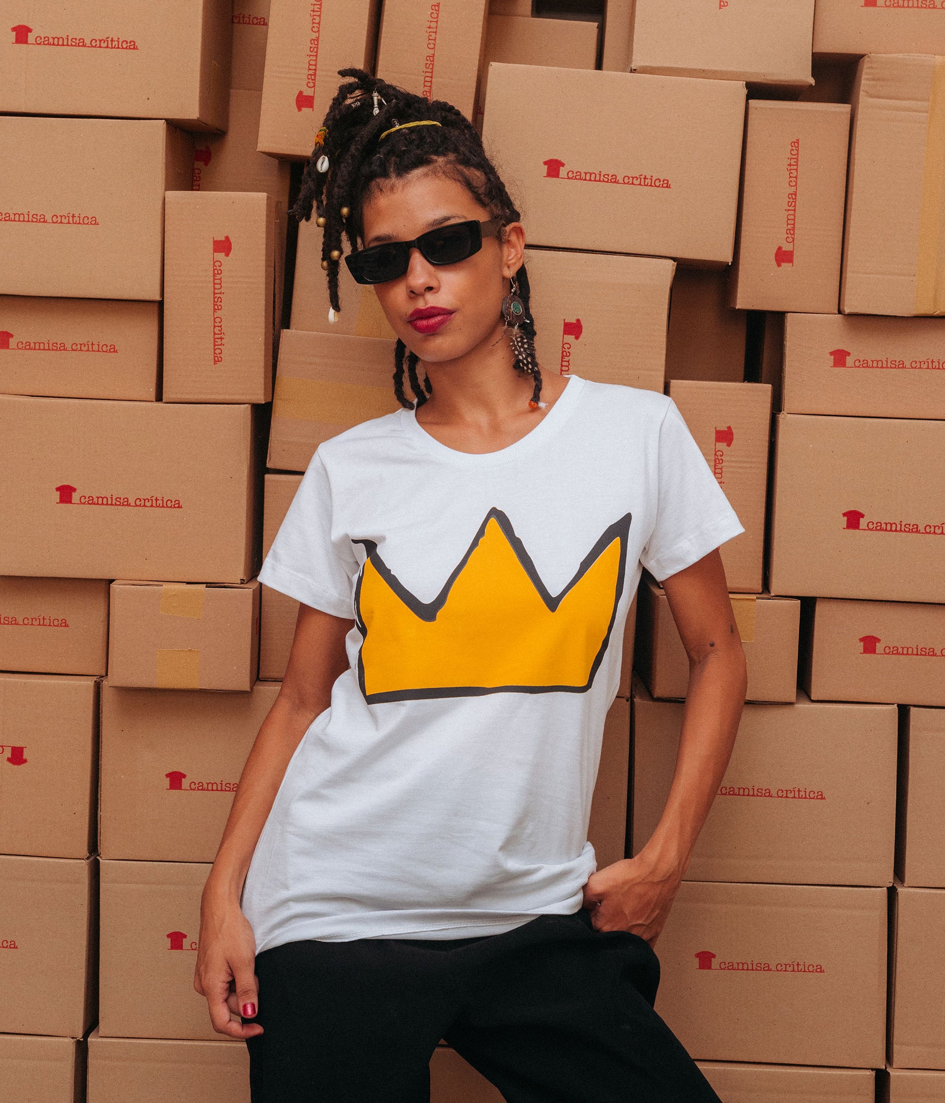 Mulher vestindo Camiseta Baby Look Estampa:  Ilustração de uma coroa ao estilo construído por Jean-Michel Basquiat.