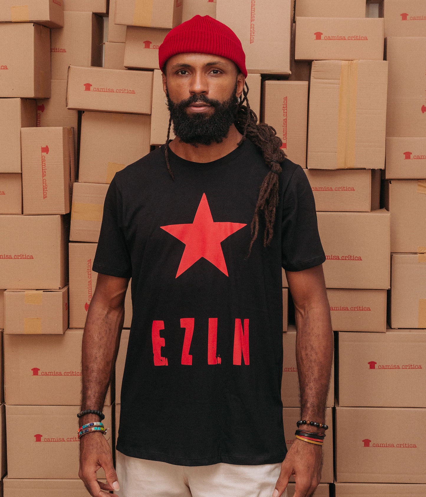 Homem vestindo Camiseta Básica Estampa: Texto escrito EZLN(Exército Zapatista de Libertação Nacional) com uma estrela acima.