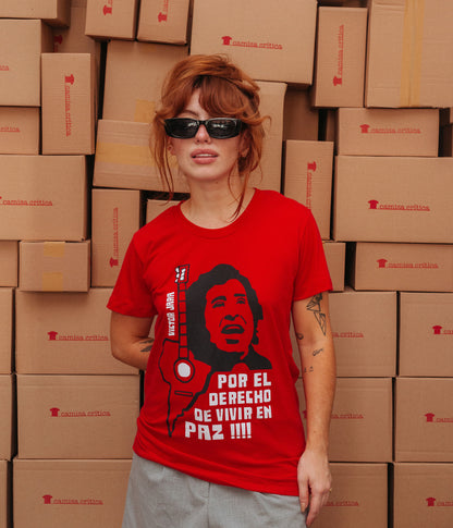 Mulher vestindo Camiseta Baby Look Estampa:  Ilustração composta de texto e imagens: texto “victor jara” à esquerda. Ainda na esquerda um violão com o tampo em formato da América do Sul. À direita encima o rosto de Victor Jara cantando e baixo dele o texto: por el derecho de vivir en paz!!!!