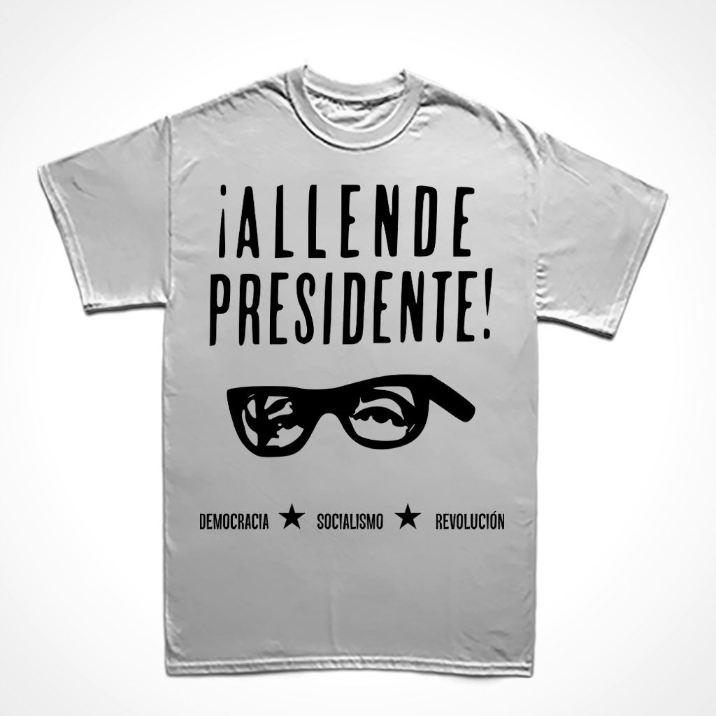 Texto Allende Presidente com acentos hispânicos, recorte dos olhos e óculos de Salvador Allende, texto no rodapé: DEMOCRACIA, SOCIALISMO e REVOLUCIÓN intercalados por duas estrelas.