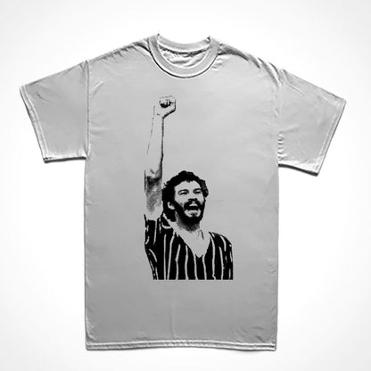 Camiseta Básica Estampa: Imagem eternizada do jogador de futebol Sócrates erguendo o punho cerrado numa partida de futebol.